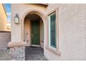 Inviting front entrance with arched doorway and stone accents at 1557 Mistywood Ct, Henderson, NV 89014