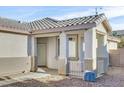 Front entrance of the house with a covered porch and a white door at 2687 Hollowvale Ln, Henderson, NV 89052