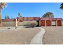 Front view of a ranch-style home with a landscaped yard and walkway at 3070 Mann St, Las Vegas, NV 89146