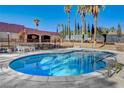 Inviting kidney-shaped pool with surrounding patio and lush landscaping at 3070 Mann St, Las Vegas, NV 89146