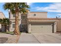 Two-story house featuring a tan stucco exterior and palm trees at 5458 Walton Heath Ave, Las Vegas, NV 89142