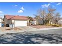 Single story home with a two car garage and landscaped yard at 1020 Blue Lantern Dr, Henderson, NV 89015