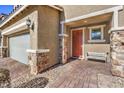 Inviting entryway with orange door, stone accents, and a bench at 10640 Skye Scout Ave, Las Vegas, NV 89166