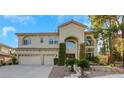 Two-story house with a three-car garage, landscaping, and a large front yard at 10779 Crown Ct, Las Vegas, NV 89141