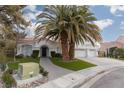 Two-story house with white exterior, palm trees, and a three-car garage at 2000 Catalina Marie Ave, Henderson, NV 89074