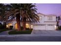 Two-story house with white exterior, palm trees, and a three-car garage at dusk at 2000 Catalina Marie Ave, Henderson, NV 89074