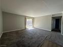 Spacious living room with grey carpet and sliding door access to a patio at 5181 River Glen Dr # 172, Las Vegas, NV 89103