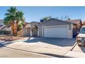 House exterior showcasing a two-car garage and palm trees at 6725 Carrera Dr, Las Vegas, NV 89103