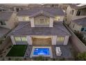 Rear exterior view of home, showcasing a private backyard with a pool, patio, and outdoor grill at 30 Hilltop Crest St, Henderson, NV 89011