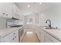 Modern kitchen with white cabinets, quartz countertops, and new appliances at 402 Dune Ridge Ave, North Las Vegas, NV 89031