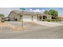 House exterior with a large driveway and mature trees at 5500 Santovito St, Pahrump, NV 89061