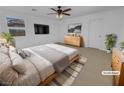 Virtually staged main bedroom with dresser and a large TV at 7100 Estrella De Mar Ave, Las Vegas, NV 89131