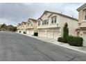 Exterior view of townhomes featuring multi-car garages and simple landscaping on a quiet street at 8834 Duncan Barrel Ave # 103, Las Vegas, NV 89178