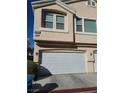 Two-car garage with white doors and exterior lighting at 8834 Duncan Barrel Ave # 103, Las Vegas, NV 89178