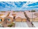 Aerial view of a tan house with a three car garage at 9644 Padre Peak Ct, Las Vegas, NV 89178