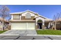 Two-story house with a three-car garage and landscaped lawn at 10016 Diving Duck Ave, Las Vegas, NV 89117