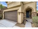 Two-car garage and front entry with stone accents at 10489 Bolting Cloud Dr, Las Vegas, NV 89178