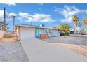 Ranch style home with gray exterior, white garage door, and landscaping at 1205 Sattes St, Las Vegas, NV 89101