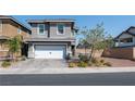 Two-story house with gray exterior, white garage door, and landscaped front yard at 126 Ostinato Ln, Henderson, NV 89015