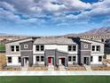 Modern 3-unit townhome building with gray and white exterior, landscaping, and mountain views at 1598 Dom River Dr # Lot 137, North Las Vegas, NV 89084