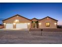 Two-story house with a three-car garage and desert landscaping at 2051 Saginaw Ave, Pahrump, NV 89048