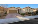 A well-kept single story home featuring a manicured front yard and a brick driveway leading to the garage at 2365 Boretto St, Henderson, NV 89044