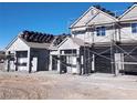 Exterior of multiple new construction homes with black garage doors at 380 Erin St, Pahrump, NV 89048