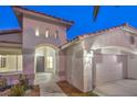 Well-lit entryway with arched doorway and access to a two-car garage at 5306 Falling Petals Dr, North Las Vegas, NV 89031