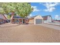 Single-story home with grey garage door and landscaped yard at 5420 Doe Ave, Las Vegas, NV 89146