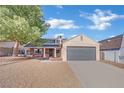 Single-story home with grey garage door and landscaped yard at 5420 Doe Ave, Las Vegas, NV 89146