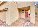 Home's front entrance with a covered porch and red door at 5658 Adobe Jack St, North Las Vegas, NV 89031