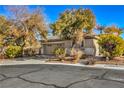 Tan house with a two-car garage and mature landscaping at 5744 Serenity Haven St, North Las Vegas, NV 89081