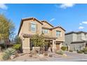 Tan two-story house with shutters, landscaping, and a paved driveway at 6332 Ava Ridge Ave, Las Vegas, NV 89141