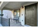 Inviting covered entryway with a metal bench, an exterior light fixture, and a coded front door at 6461 Karlsen Ct, Las Vegas, NV 89122