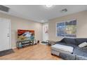 Cozy living room featuring hardwood floors, large window, and a comfortable couch at 6461 Karlsen Ct, Las Vegas, NV 89122