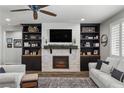 Spacious living room with fireplace, built-in shelving, and hardwood floors at 9820 Maiden Pink Ave, Las Vegas, NV 89149