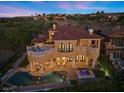 Private backyard features a sparkling pool and spa, a covered patio, and lush landscaping for relaxing and entertaining at 17 Rue Du Rivoli Pl, Henderson, NV 89011