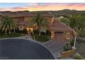 Elegant two-story home features a tile roof, porte-cochere, lush landscaping, and a welcoming circular driveway at 17 Rue Du Rivoli Pl, Henderson, NV 89011