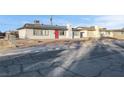 Gray house with red door, solar panels, and a gravel driveway at 213 Valley Forge Ave, Henderson, NV 89015