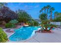 Inviting pool and spa area with lush landscaping and palm trees at 4649 Bird View Ct, Las Vegas, NV 89129