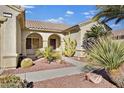 Front entry of house with walkway, arched entryway, and desert landscaping at 1647 Fieldbrook St, Henderson, NV 89052