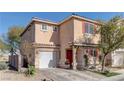 Two-story house with tan exterior, red door, and attached garage at 3728 Spiritual Way, Las Vegas, NV 89115