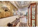 Elegant entryway, featuring a bench and display cabinet, leading to living room at 3918 Champagne Wood Dr, North Las Vegas, NV 89031