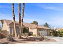 Single-story house with tan walls, tile roof, and a two-car garage at 4609 Snowpoint Ct, Las Vegas, NV 89130