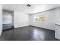 Bright living room featuring dark laminate flooring and a large window for natural light at 4981 Alondra Dr, Las Vegas, NV 89118