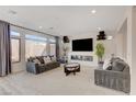 Modern living room with large windows, plush seating, fireplace, and mounted TV at 8749 Black Cordon Rd, Las Vegas, NV 89139