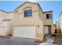 Beige two-story house with a white garage door and small yard at 2503 Lady Elizabeth Ct, North Las Vegas, NV 89031