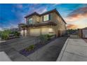 Two-story home with tan exterior, three-car garage, side yard with drought tolerant landscaping at 3109 Madame Plantier Ave, North Las Vegas, NV 89081