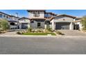 Modern two-story house with stone accents and a three-car garage at 32 Grand Corniche Dr, Henderson, NV 89011