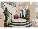 Elegant foyer with soaring ceilings, chandelier, curved staircase, and tile flooring at 5455 San Florentine Ave, Las Vegas, NV 89141